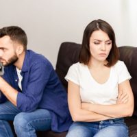 unhappy couple sitting in the living room