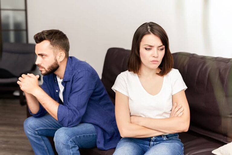 unhappy couple sitting in the living room