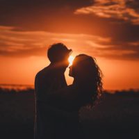 silhouette of couple on sunset about to kiss