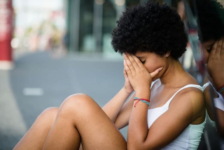 mujer triste sentada en el suelo
