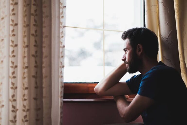 young man looking through the window