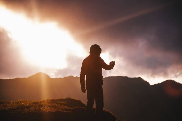 silhouette of man standing on a cliff