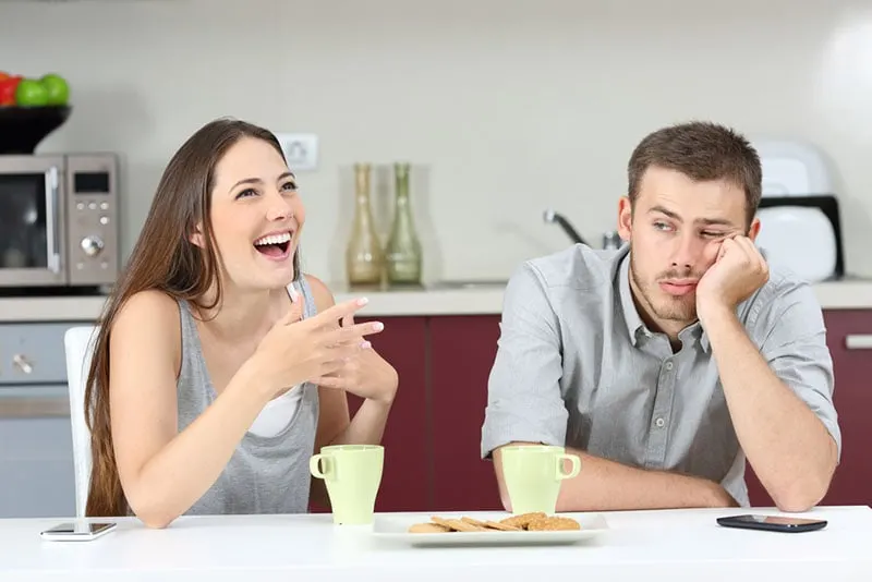 annoyed man sitting while woman talking a lot