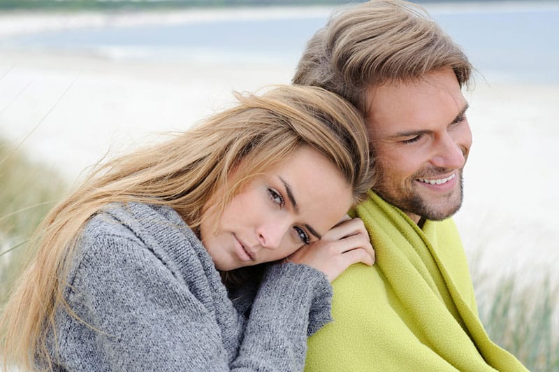 beautiful woman sitting by her man in nature