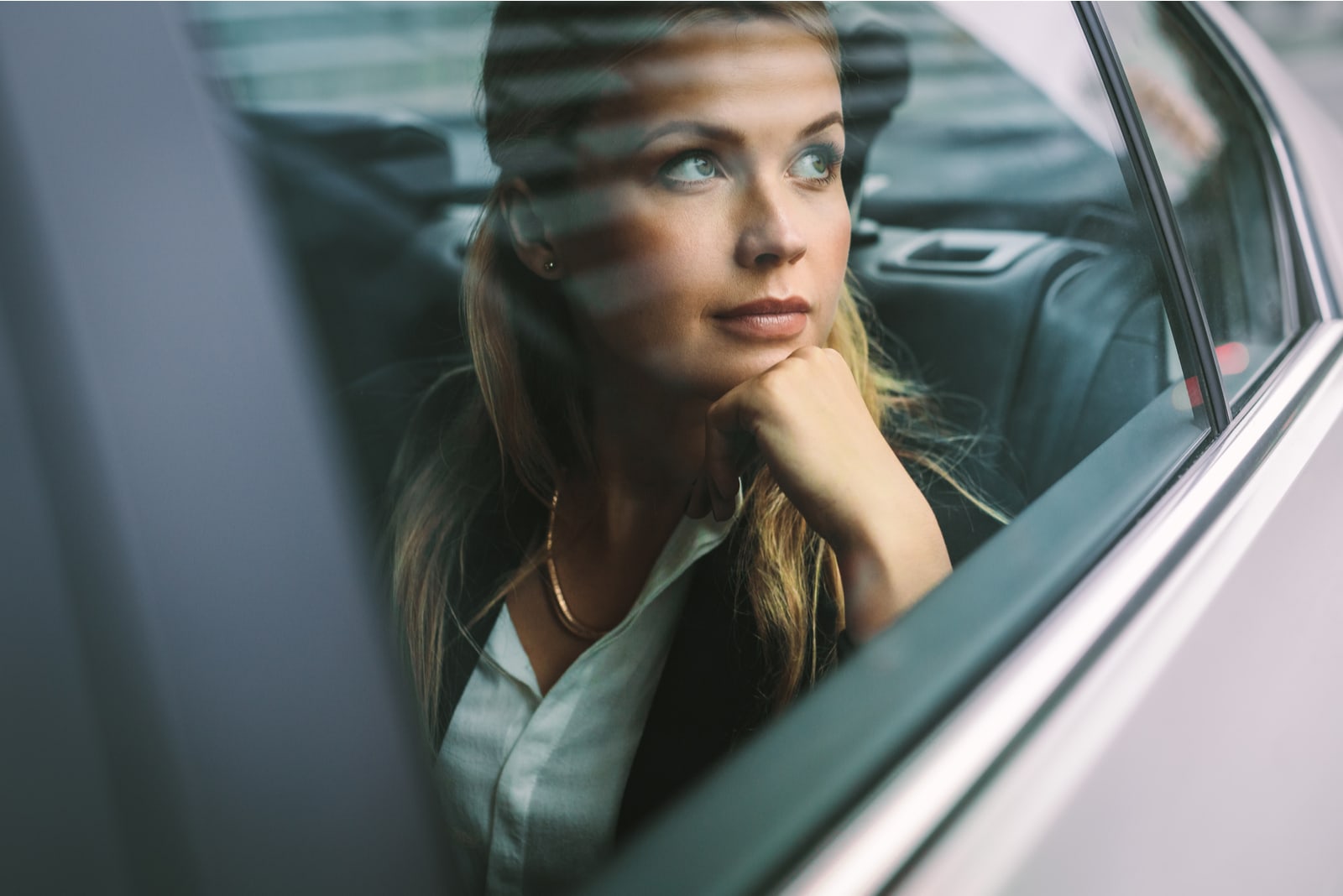 businesswoman sitting on back seat of a car 
