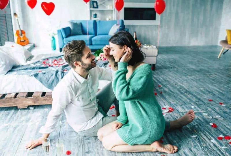 couple sitting together on the floor in romantic bedroom