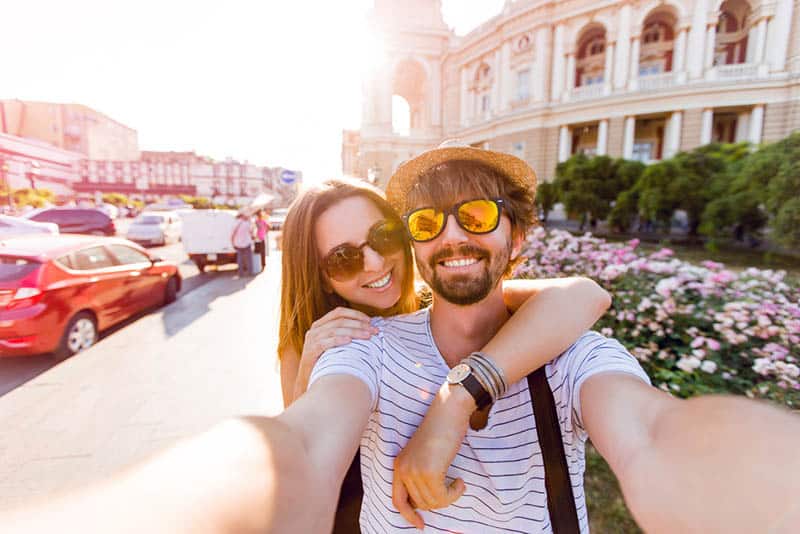 coppia che si scatta un selfie sul marciapiede