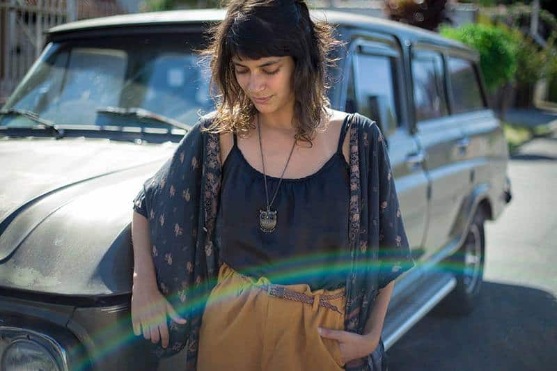 chica apoyada en un coche en el exterior