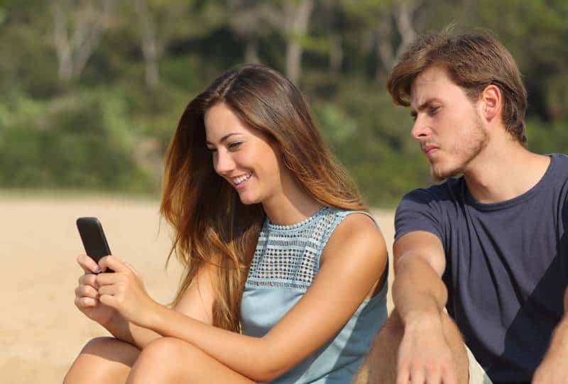 uomo geloso che guarda il telefono di una donna