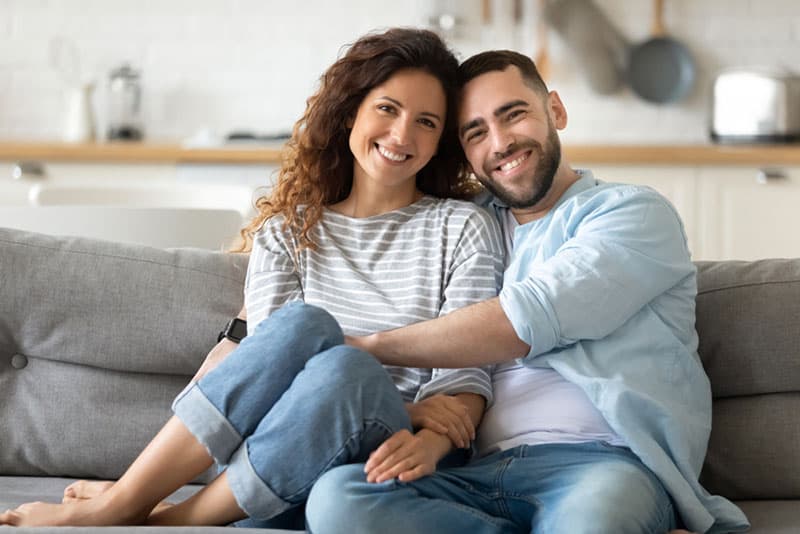 casal encantador sentado no sofá