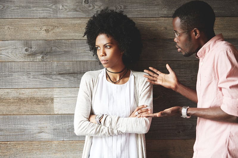 homem a discutir com uma mulher enquanto ela olha para o lado