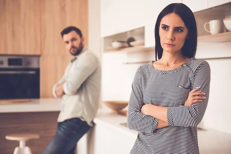 man looking at angry woman in the kitchen