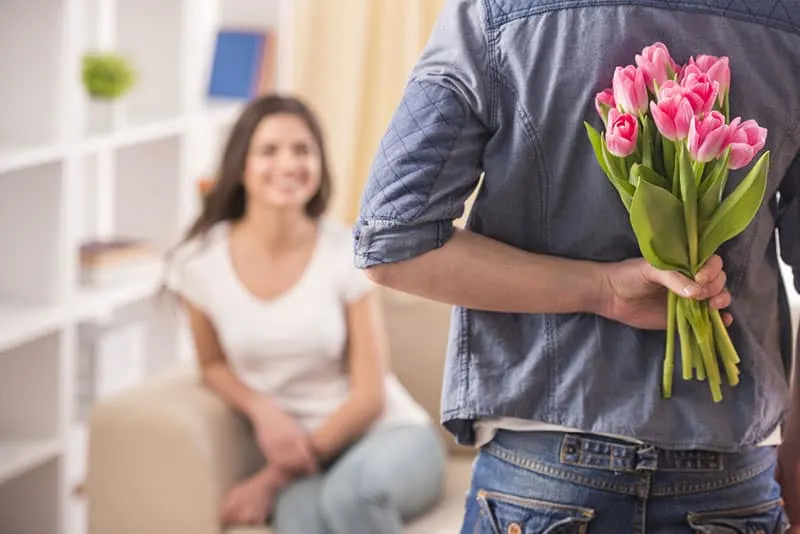 man surprising woman with tulips