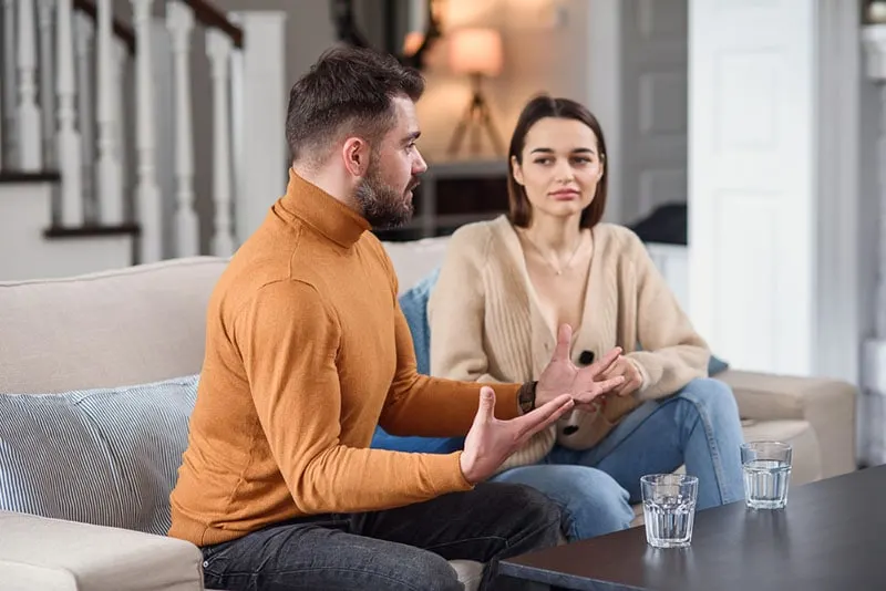 man talking to woman in the living room