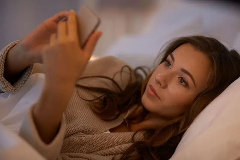 pretty woman texting in bed