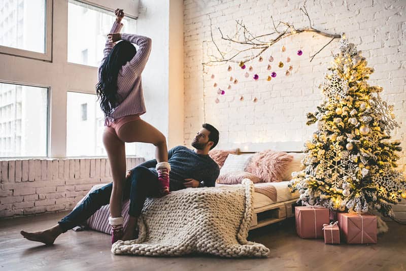 sexy woman playing with man in the living room