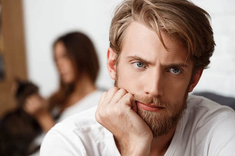 shallow focus of thoughtful man sitting next to woman at home