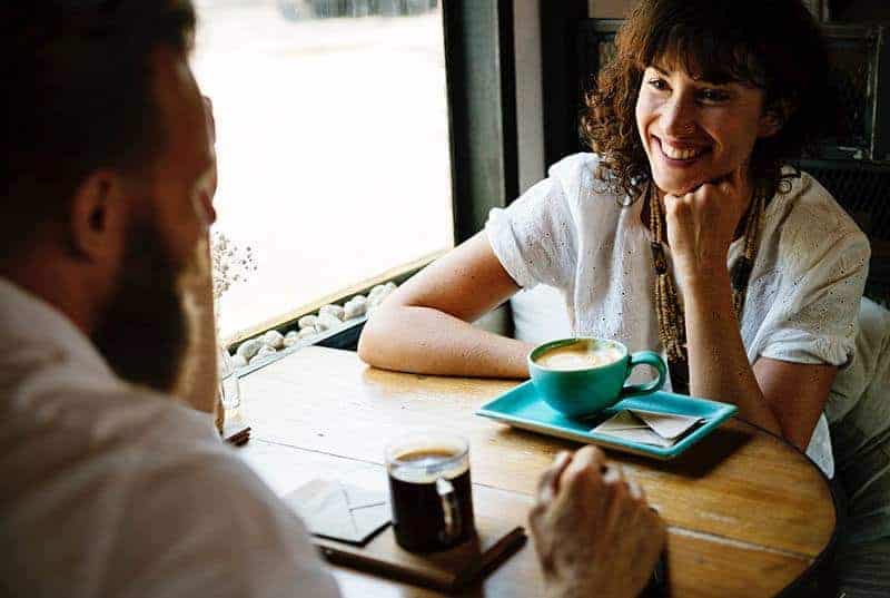 smiling couple looking each other in cafe
