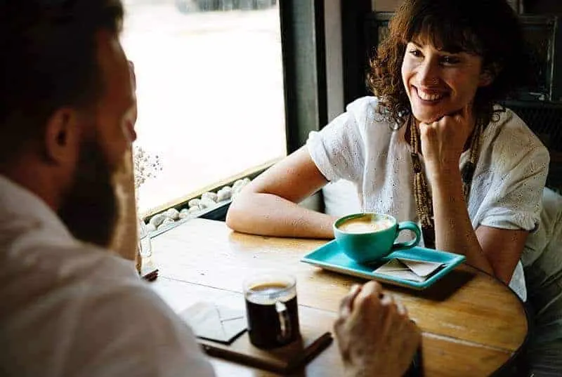 smiling couple looking each other in cafe