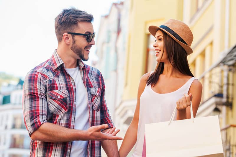 mujer sonriente hablando con un hombre en la calle