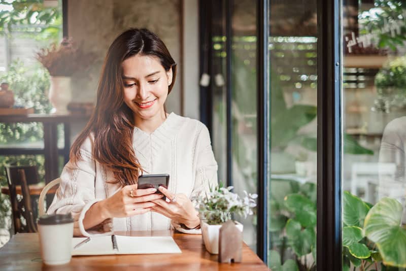 mujer sonriente enviando mensajes de texto