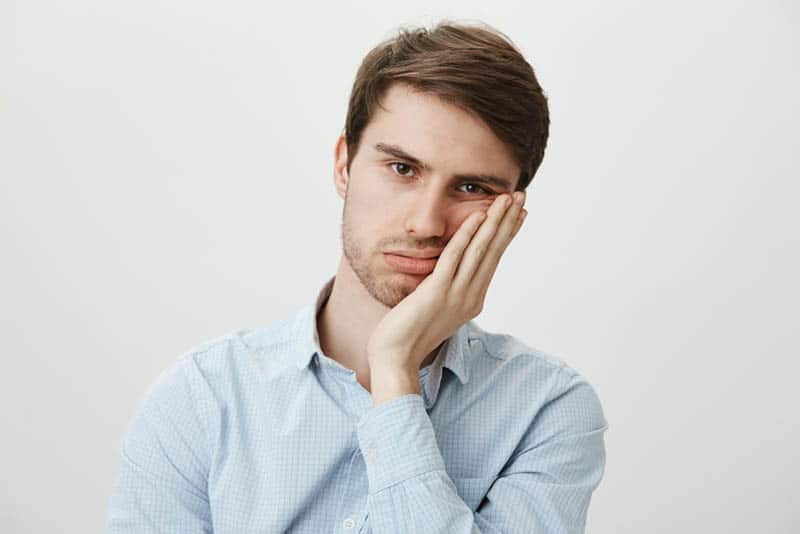 homem pensativo com camisa azul