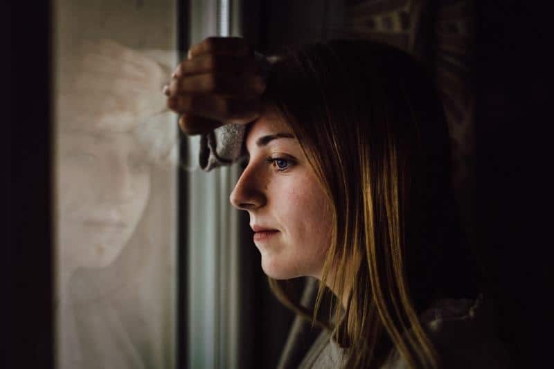 mujer pensativa mirando al exterior