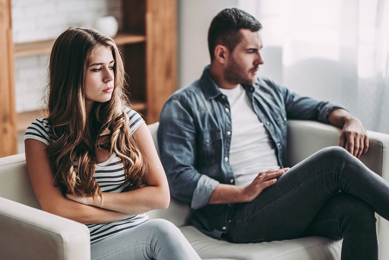 unhappy couple sitting in the living room