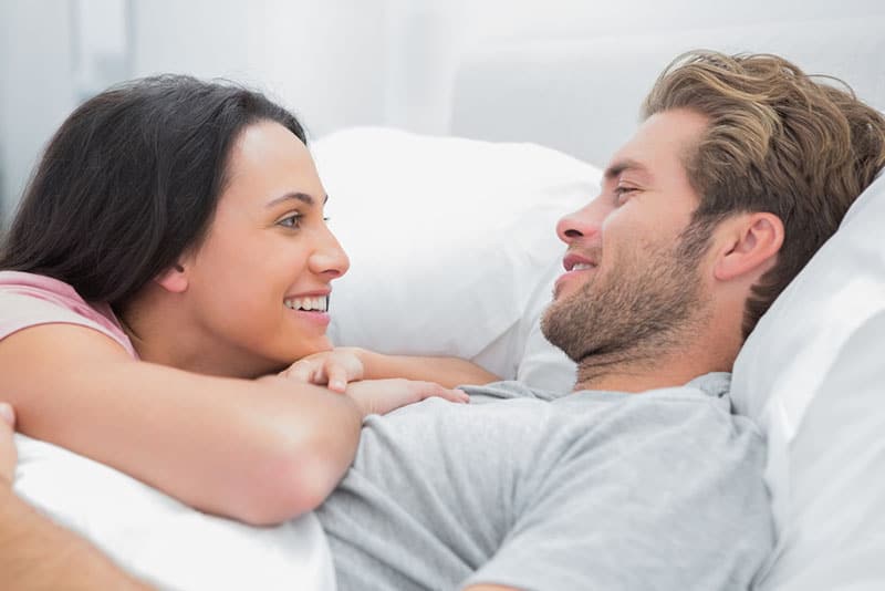 mujer enamorada mirando a su hombre en la cama