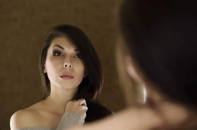 woman looking at herself in the mirror