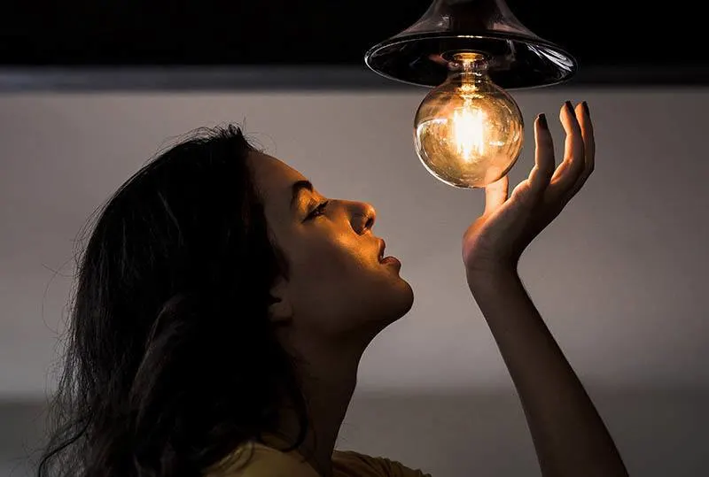 woman looking at light bulb