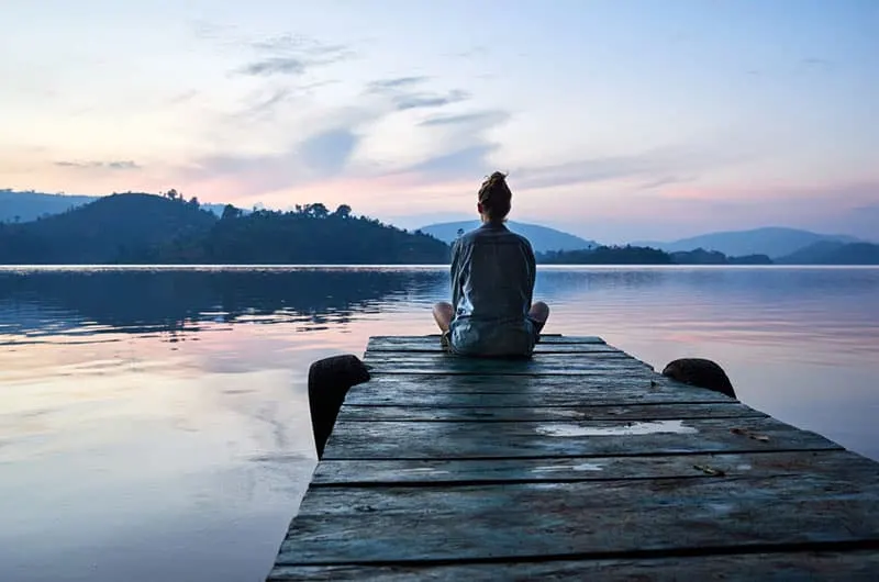 woman sitting by the lake alone