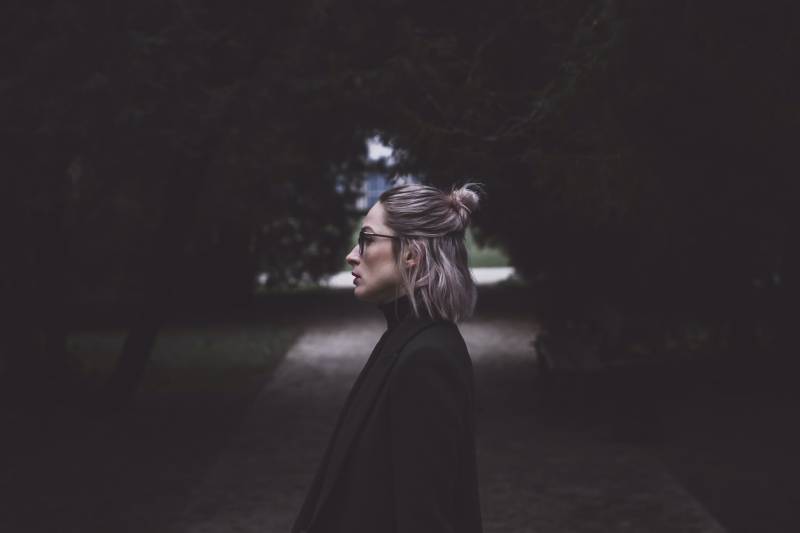 woman standing between trees