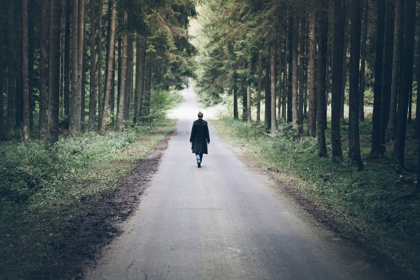 woman walking on narrow road 