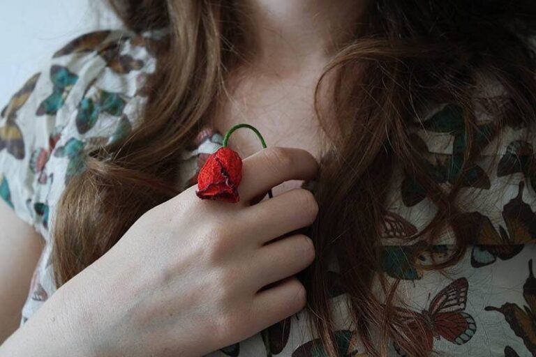 close up photo of woman holding small rose