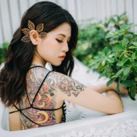 mujer asiática con tatuaje posando