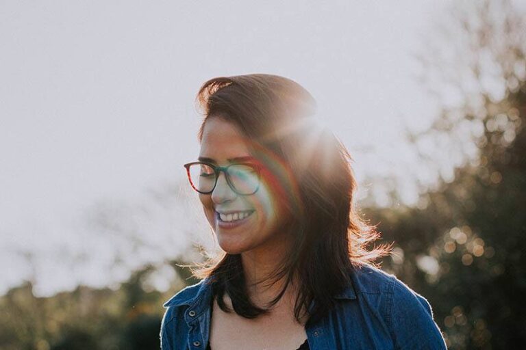 portrait of smiling woman with eyeglasses outdoors