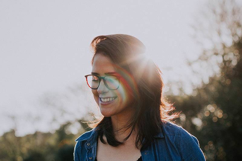 portrait of smiling woman with eyeglasses outdoors