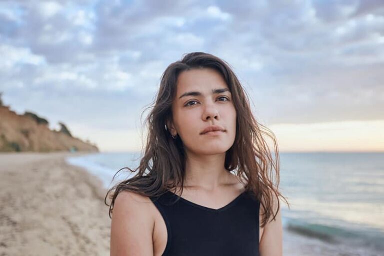 donna triste in piedi sulla spiaggia