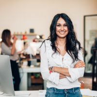 uma mulher de cabelo preto comprido ri-se