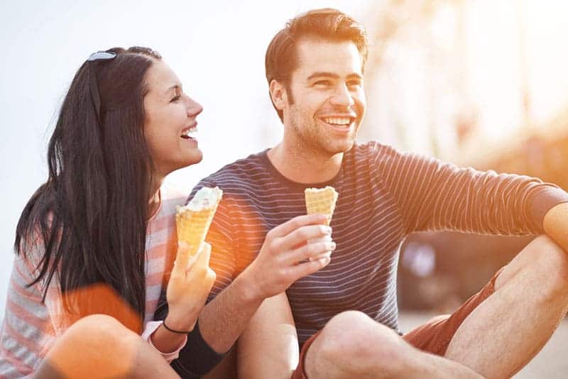 La pareja ríe y come helado