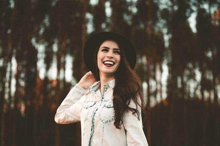 smiling woman surrounded by trees