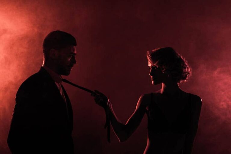 woman holds the man by the tie