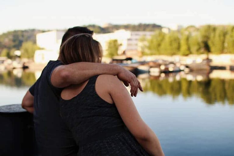 man and woman hugging by the lake