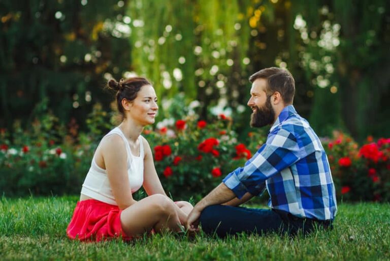 happy couple talking on grass