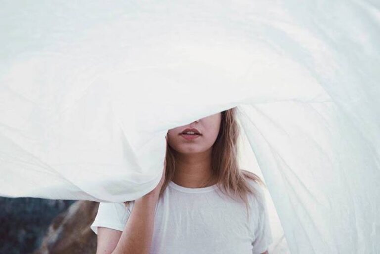 woman holds white blanket