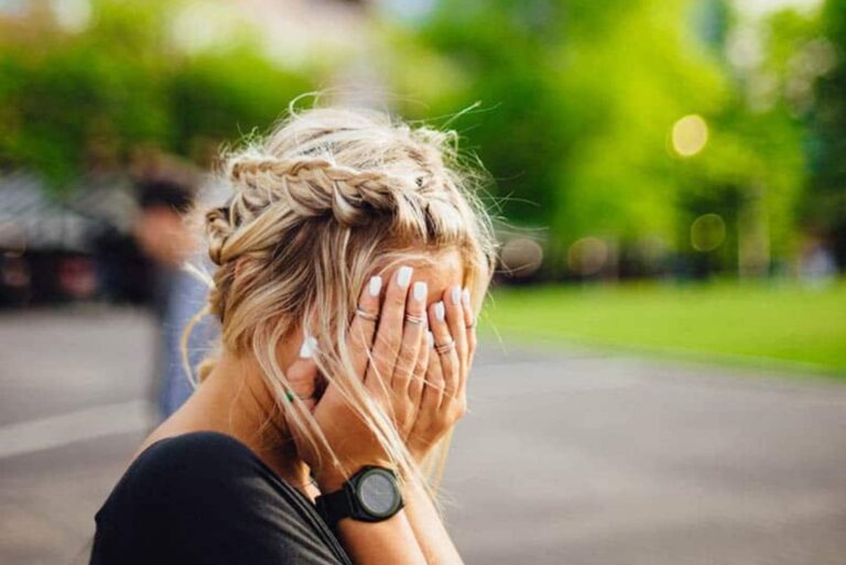 the blonde-haired woman put her hands to her face