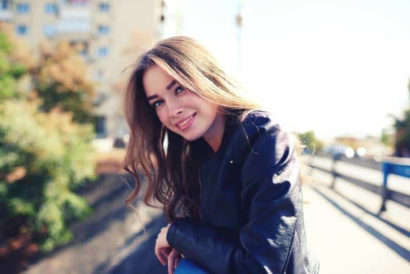 Retrato de mujer sonriente y feliz de pie en la plaza