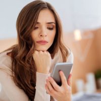 sad woman looking at phone