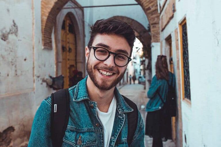 portrait of smiling man wearing eyeglasses and standing outside
